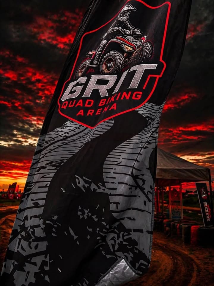 GRIT Quad Biking Arena flag against a red sky
